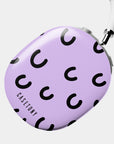 One side closer look of the Cosmic Giggles AirPods Max Case, featuring a lavender background with playful black crescent patterns, designed for a chic and unique look.