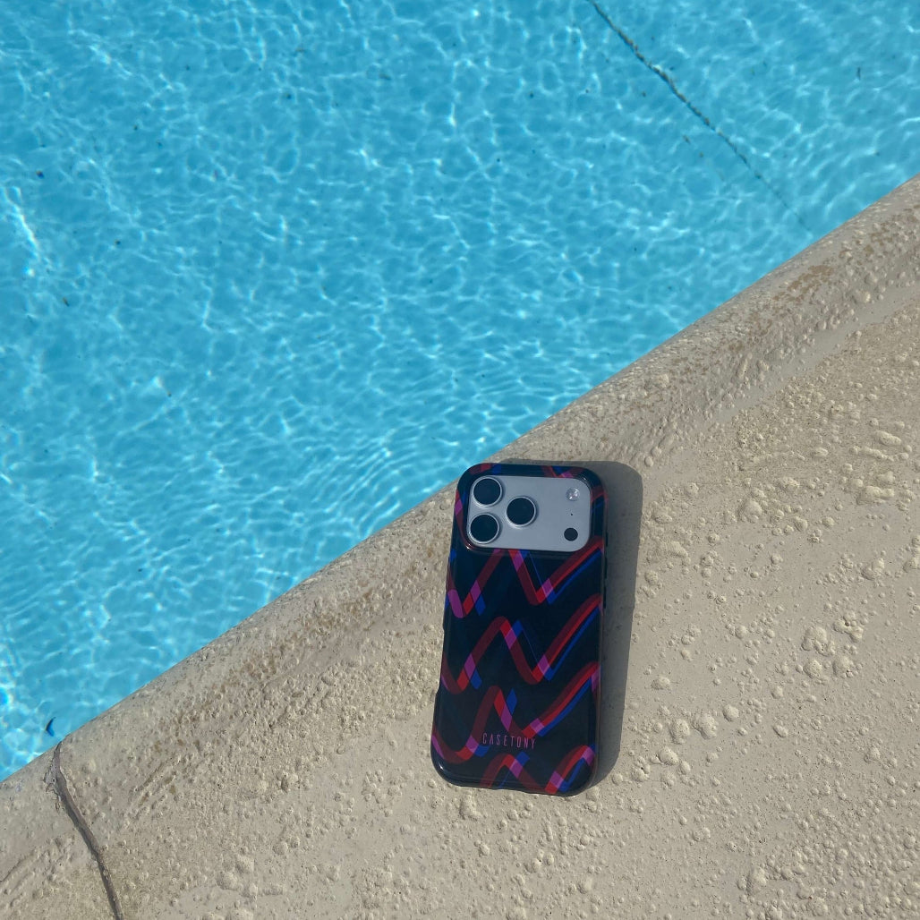 Phone case with geometric pattern on a poolside ledge